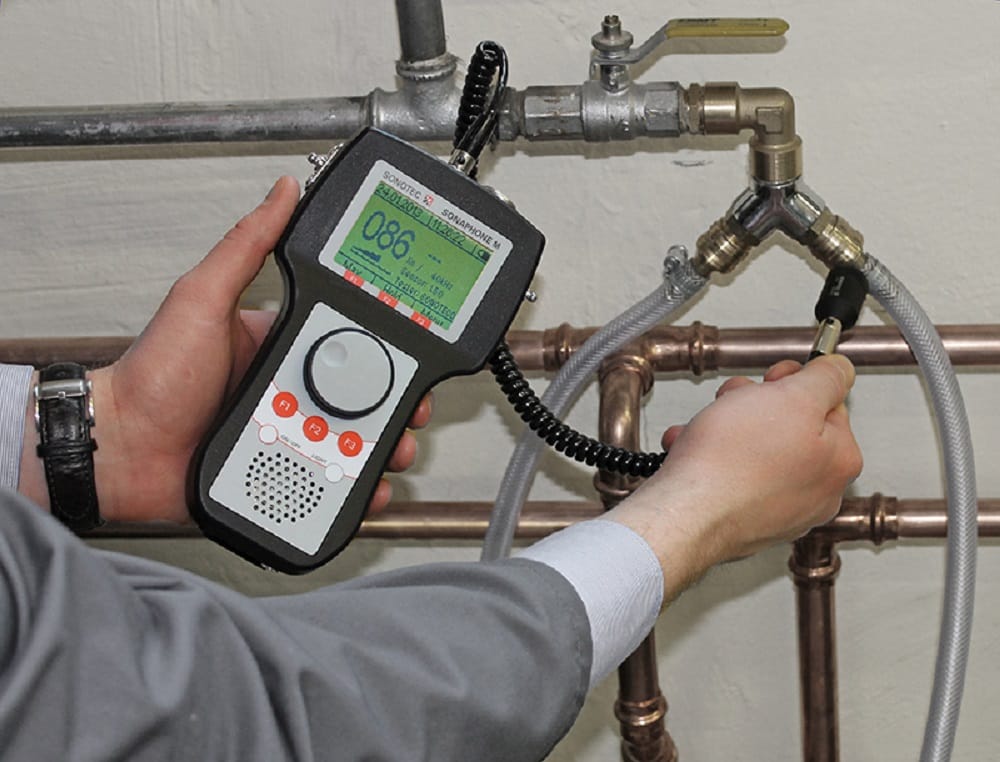 Plumber testing pipes with electronic leak detection equipment in Pittsburgh