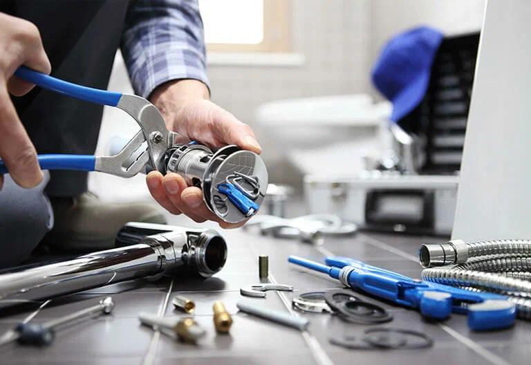 Technician repairing a plumbing fixture with professional tools in Pittsburgh