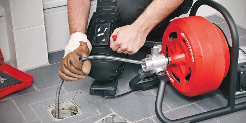 Plumber using a drain-cleaning machine in Pittsburgh